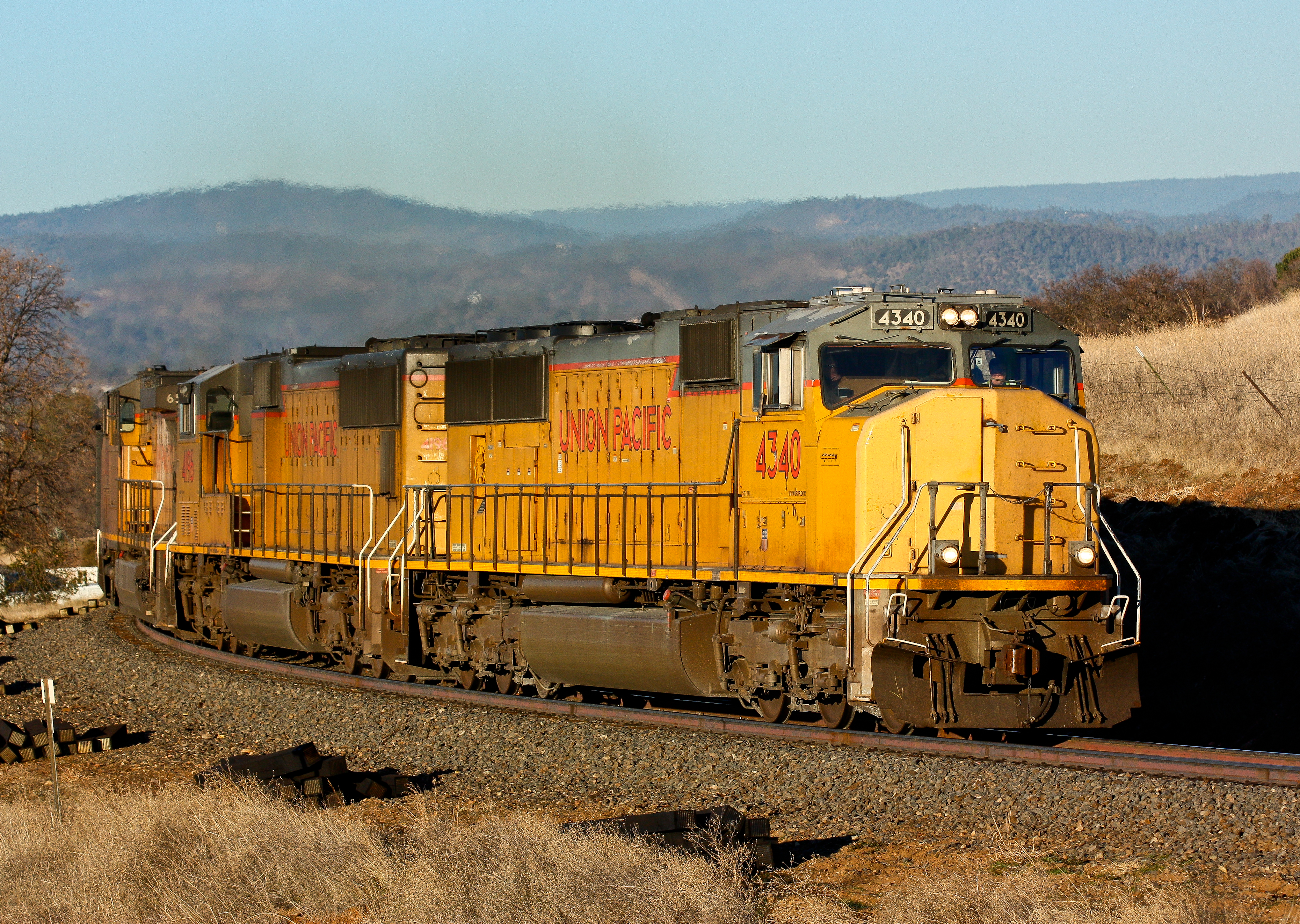 An ethanol train from the midwest rumbles through Oroville, California with the Sierra Nevada Mountains providing the backdrop.